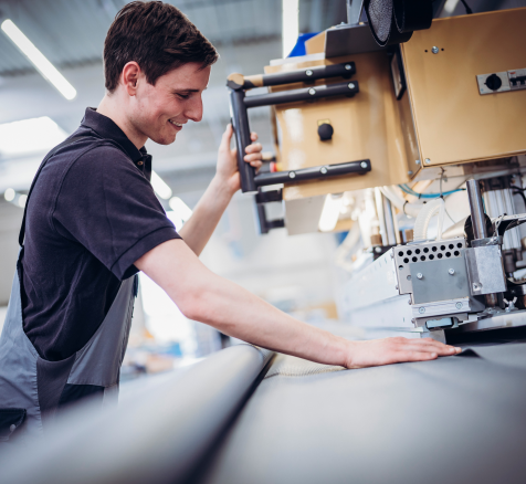 Employee uses machine for cutting at HUESKER