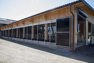 Exterior view of a dairy cow barn with a barn climate control system