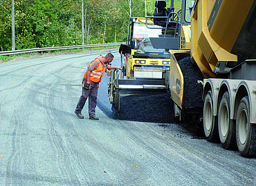 Construction machinery laying the new tarmac.