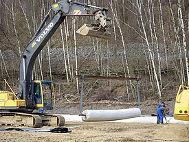 With the help of a crane and special geosynthetics an old landfill is sealed