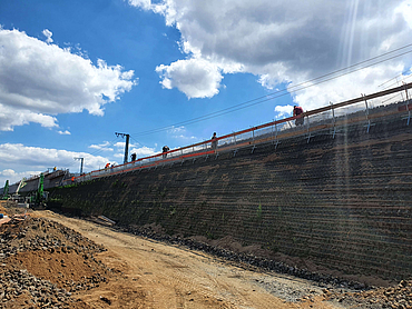 Bauarbeiter bei der Bearbeitung an einer Lärmschutzwand 