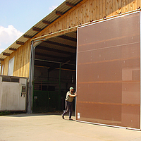 Farmer opens Lubratec sliding front on a stable building