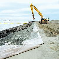 Excavation work on the beach for the placement of stones