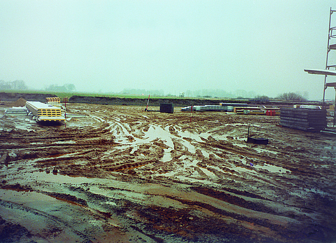 A muddy building site with some building materials