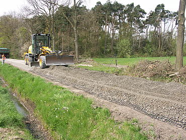 Gravel is spread on Basetrac Grid using construction machinery