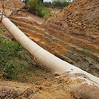 Workers attach the Incomat® Pipeline Cover to the pipe section