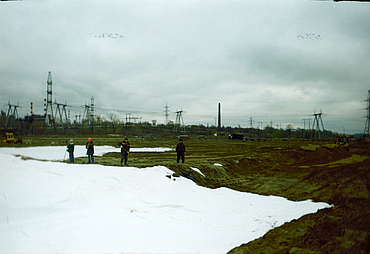 Workers standing next to a large area where Stabilenka has been laid