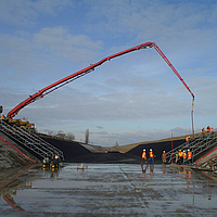 Concrete being poured over Huesker Canal³ membrane in a canal