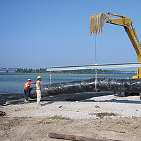 Professional installation of a filter layer on a waterbody bed to prevent contaminant release