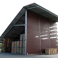 Windbreak net on a warehouse for wood splitting