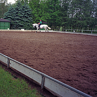 Riding arena with Lubratec separation layer and rider on white horse