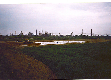 A large building site with various pieces of construction machinery and workers