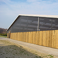 Exterior view of a horse stable with Lubratec wind protection system installed