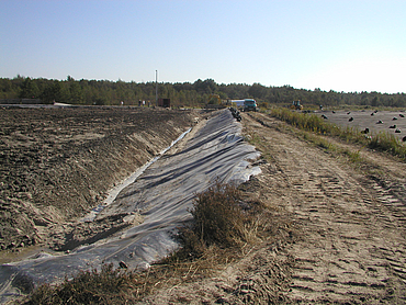 Construction machinery travelling along the trench and the dirt track