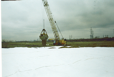 An excavator is spreading small mounds of earth across Stabilenka