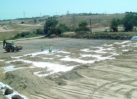 Aerial view of a building site with several workers and a wheel loader