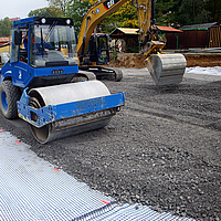 Roller compacts gravel and crushed stone on Basetrac® Duo-C geocomposite