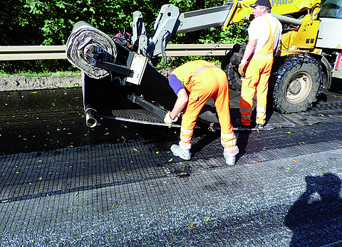 PVA asphalt reinforcement is laid by staff.