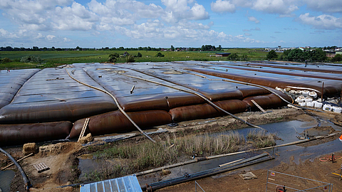 Geotextile containers and dewatering hoses from HUESKER for sustainable sludge dewatering and watercourse remediation, ideal for shoreline and coastal protection projects.