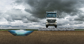 Truck on a construction road made of fabrics and composites as a stable road alternative to the soft subsoil of the adjacent riverbed